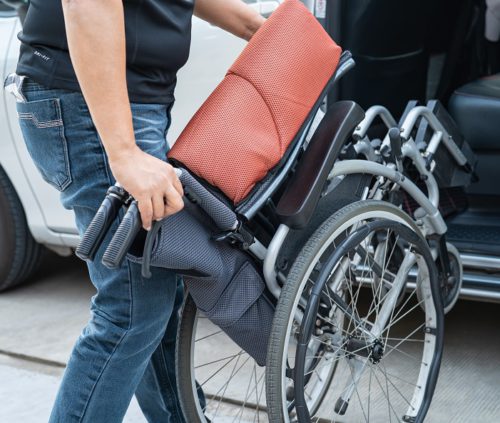 person lifting a manual wheelchair