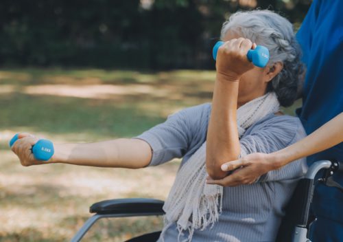 person using hand weights while seated on wheelchair